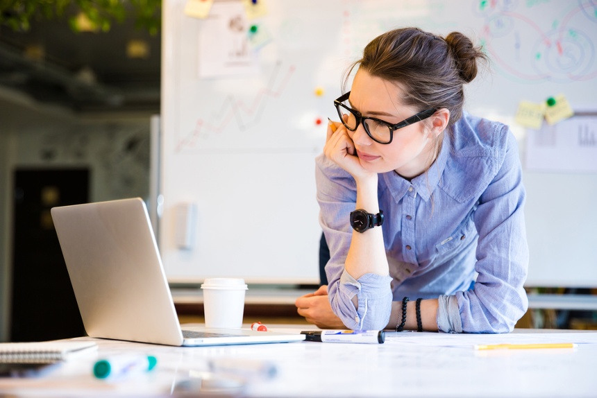 young businesswoman looking frustratedly at her laptop