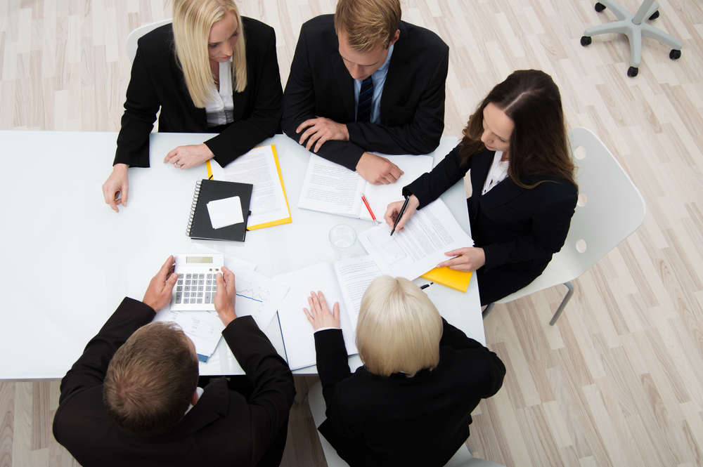 High angle view of a group of young successful businesspeople in a meeting analyzing and planning a new strategy (1)