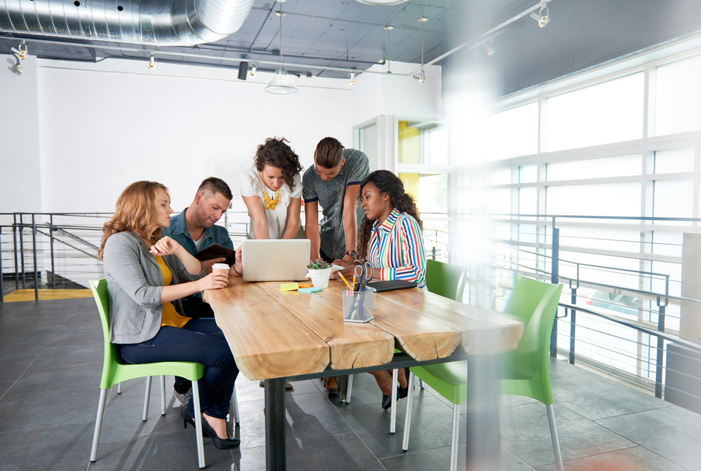 group-of-succesful-creative-business-people-using-a-laptop-during-candid-meeting